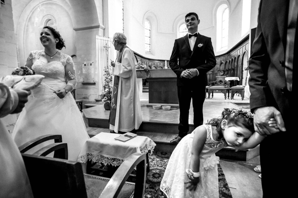 photo comique de l'enfant des mariés très impatient lors de la sortie de l'église en Vendée